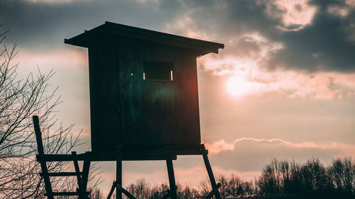 Low angle view of water tower against sky during sunset