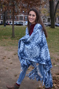 Portrait of young woman with shawl walking at park