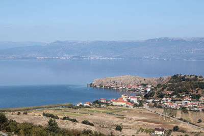 High angle view of townscape by sea against sky