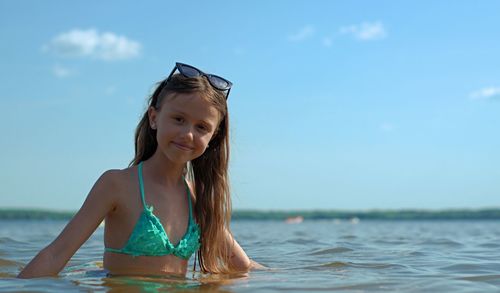 Portrait of smiling woman in sea against sky