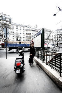 Cars on street in city against sky