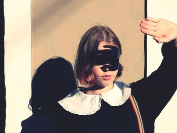 Portrait of woman holding girl against wall