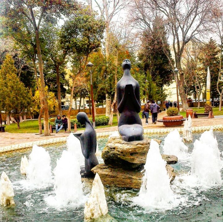 water, tree, fountain, statue, sculpture, motion, park - man made space, flowing water, spraying, splashing, human representation, art and craft, art, day, waterfront, flowing, nature, pond