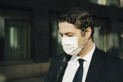 Businessman with face mask looking down