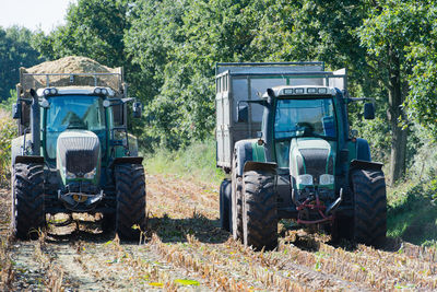 Tractors on field against trees