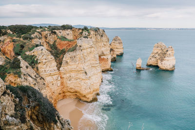 Panoramic view of cliff by sea against sky