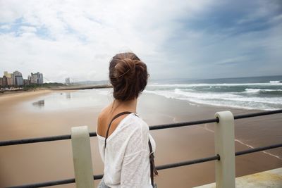 Rear view of woman looking at sea against sky