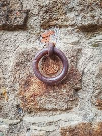 Close-up of rusty metal hanging against wall