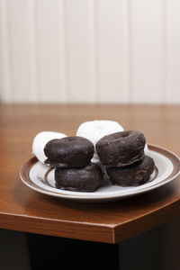 Stack of chocolate donuts in front of a stack of powdered donuts