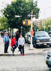 Rear view of people walking on street in city