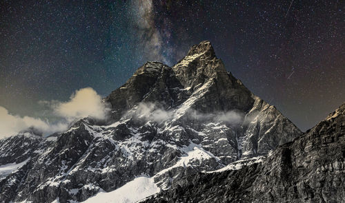 Scenic view of snowcapped mountains against sky at night