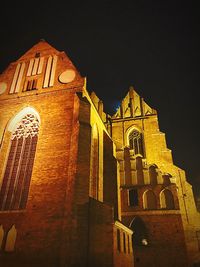 Low angle view of illuminated building against sky at night