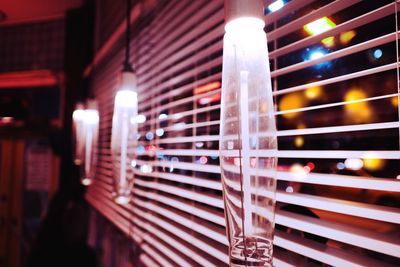 Close-up of illuminated lamp on table against building