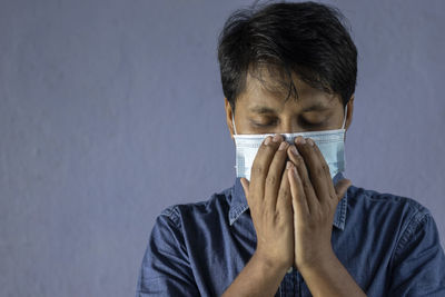 Health problem and people concept - unhealthy indian man coughing with nose mask on