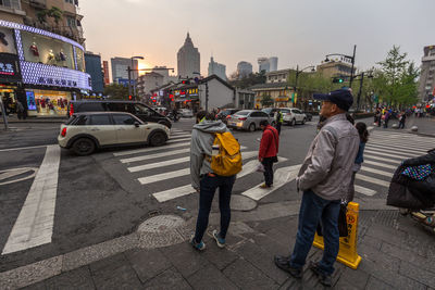 Rear view of people walking on street in city