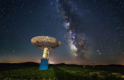 Low angle view of communications tower against sky at night