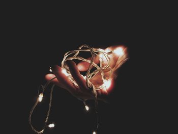 Close-up of illuminated lighting equipment against black background