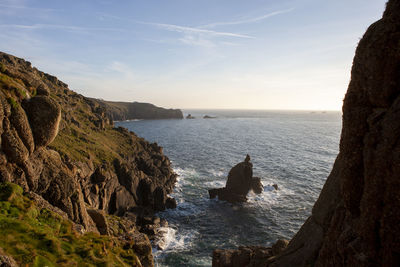 Rock formations by sea against sky