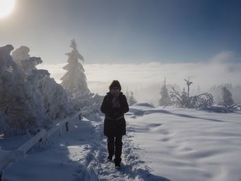 Portrait of woman standing on snow covered field