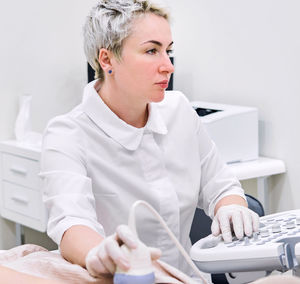 Gynecologist examining patient at hospital