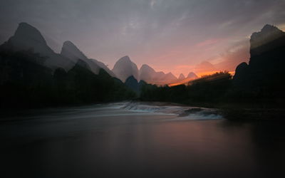 Scenic view of river against sky during sunset