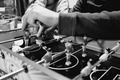 Cropped image of friends playing foosball