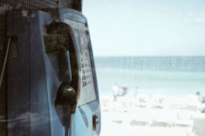 Close-up of telephone booth against sky