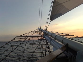 Ship sailing on sea against sky during sunset