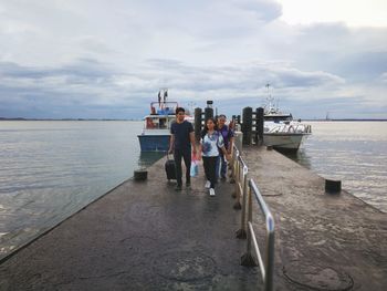 People standing on beach against sky