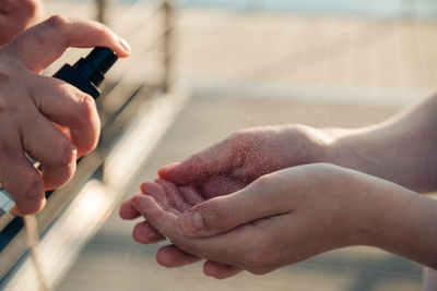 Close-up of person spraying sanitizer on hand