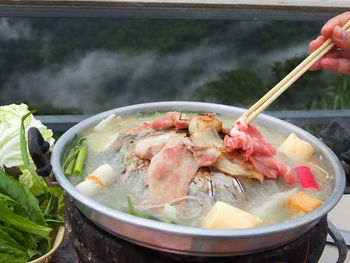 Close-up of hand holding food in bowl