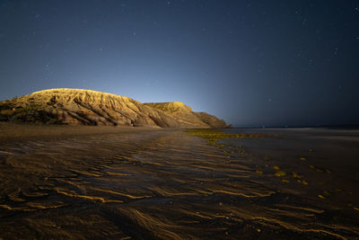 Scenic view of beach against sky at night