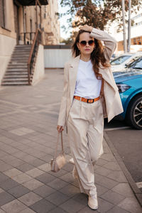 Young woman in white pantsuit and white t-shirt in city location