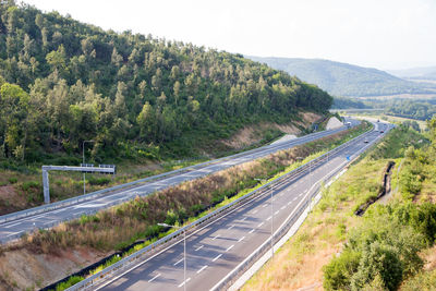 High angle view of highway by trees against sky