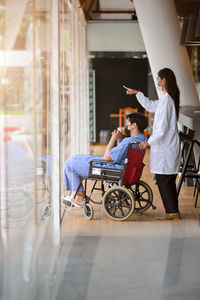 Side view of doctor showing something to patient at hospital