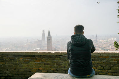 Rear view of man standing against building