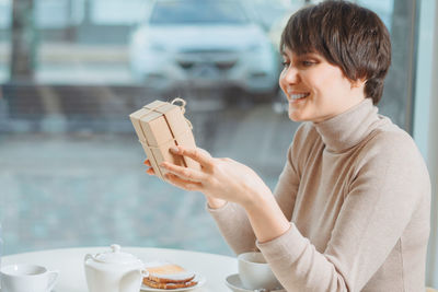 Portrait of man holding coffee cup on table