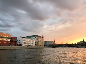 Buildings at waterfront during sunset