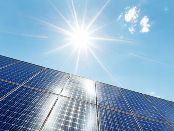 3d rendering of solar panels against the blue sky and sun