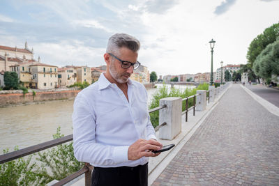 Businessman using mobile phone while standing outdoors
