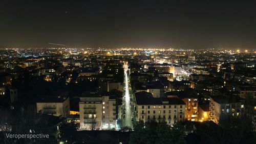 Illuminated cityscape against sky at night