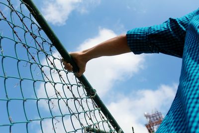 Low angle view of hand against blue sky