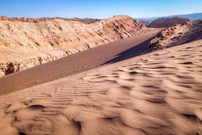 Sand dunes in desert against sky