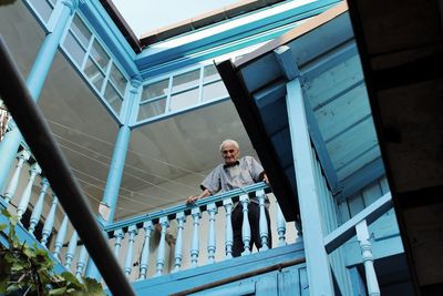 Low angle view of man looking over banister