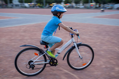Boy riding bicycle on street