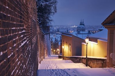 Snow covered houses and buildings against sky during winter