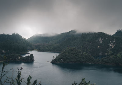 Scenic view of river and mountains against sky