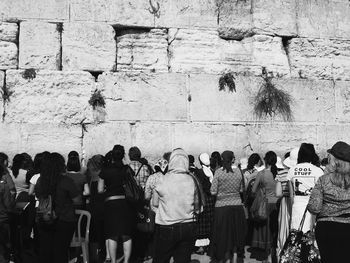 People standing against graffiti wall