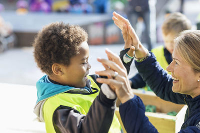 Teacher giving high-five to student outside kindergarten