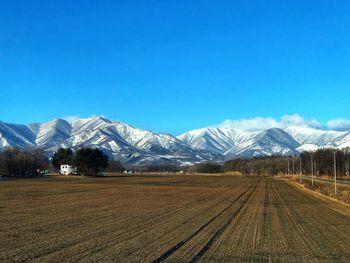 Scenic view of snowcapped mountains against blue sky